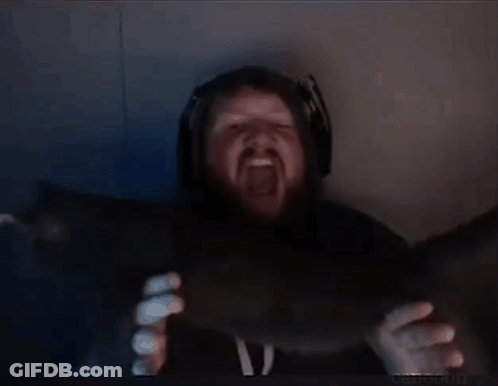 A Man With A Beard And Headphones Is Holding Something In His Hands In A Dark Room . GIF