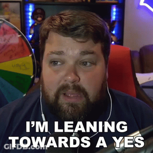 A Man With A Beard And Headphones Is Leaning Towards A Yes . GIF