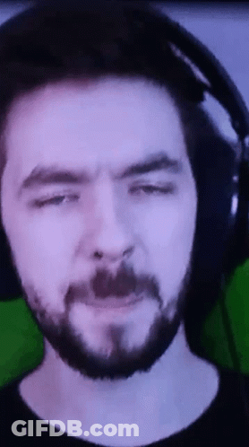 A Man With A Beard And Headphones Is Making A Funny Face . GIF