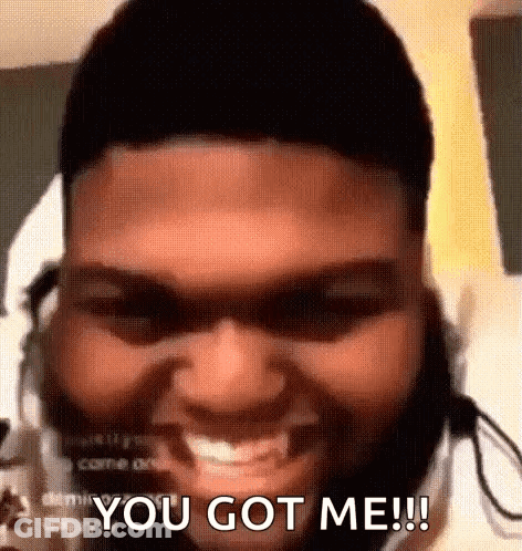 A Man With A Beard And Headphones Is Smiling And Saying `` You Got Me '' . GIF
