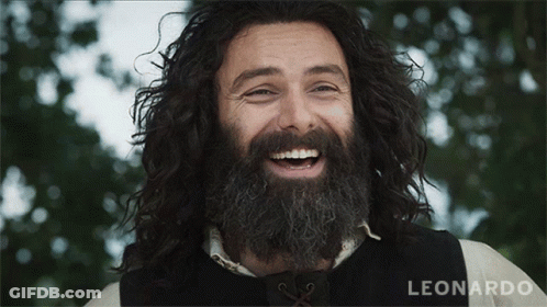A Man With A Beard And Long Hair Is Smiling And The Name Leonardo Is Visible In The Corner GIF