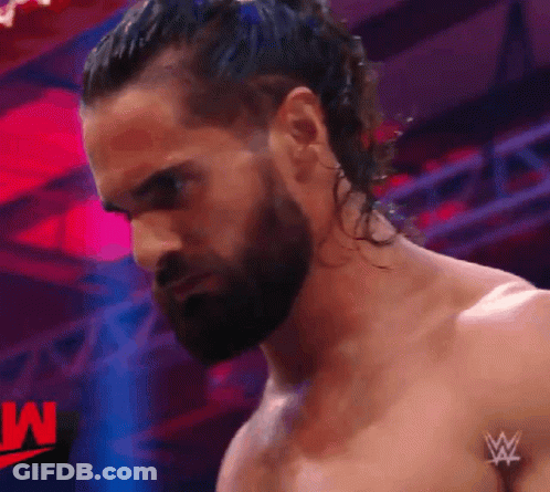 A Man With A Beard And Long Hair Is Standing In Front Of A W Logo GIF