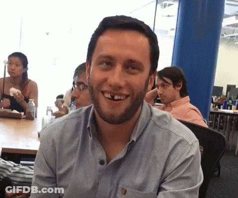 A Man With A Beard And Missing Teeth Is Smiling GIF