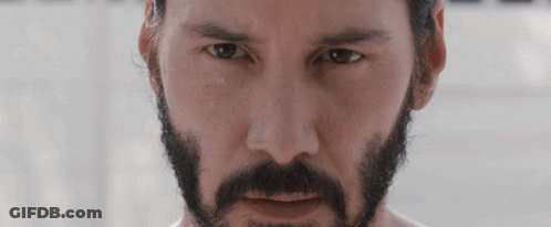 A Man With A Beard And Mustache Is Looking At The Camera GIF