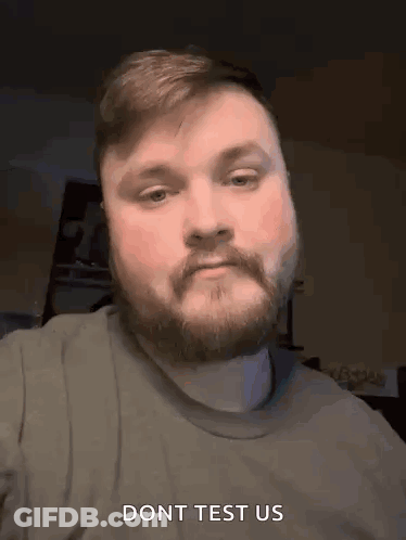 A Man With A Beard And Mustache Is Making A Funny Face And Says Do N't Test Us . GIF