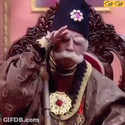 A Man With A Beard And Mustache Is Sitting In A Chair With His Hand On His Face . GIF