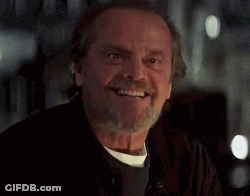 A Man With A Beard And Mustache Is Smiling And Looking At The Camera . GIF