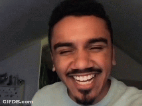 A Man With A Beard And Mustache Is Smiling GIF