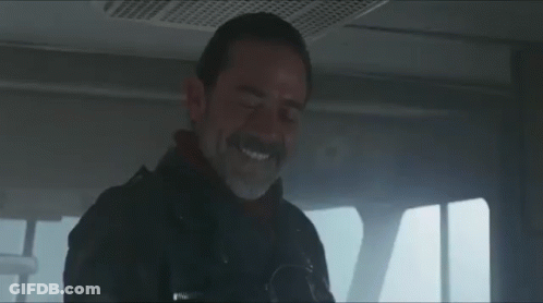 A Man With A Beard And Mustache Is Smiling While Sitting In A Car . GIF