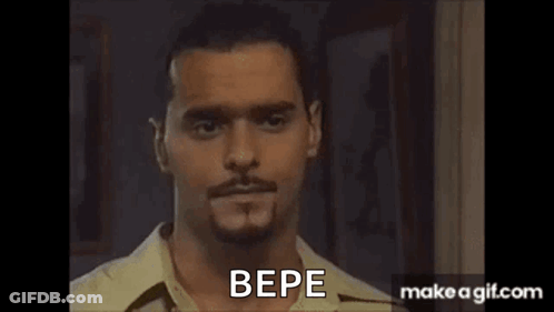 A Man With A Beard And Mustache Is Standing In Front Of A Door And Talking To Someone . GIF