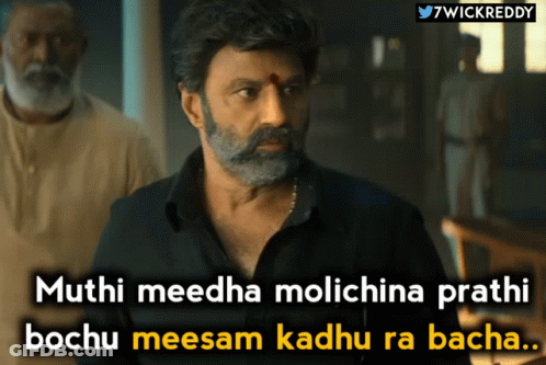 A Man With A Beard And Mustache Is Standing In Front Of A Sign That Says " 7Wickreddy " GIF