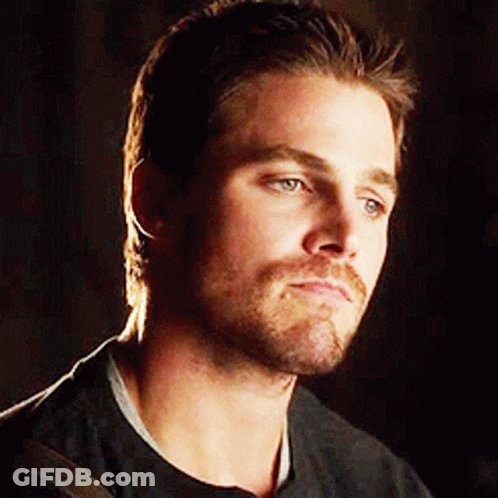 A Man With A Beard And Mustache Is Wearing A Black Shirt And Looking At The Camera . GIF