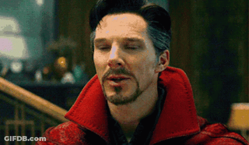 A Man With A Beard And Mustache Is Wearing A Red Coat And Making A Funny Face With His Eyes Closed . GIF