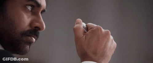 A Man With A Beard And Mustache Is Wearing A White Shirt And A Black Suit GIF