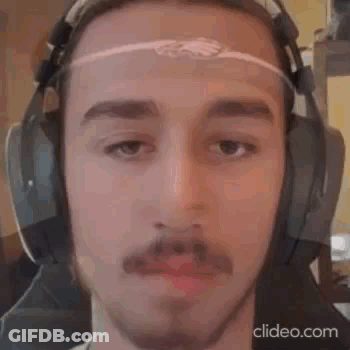 A Man With A Beard And Mustache Is Wearing Headphones . GIF
