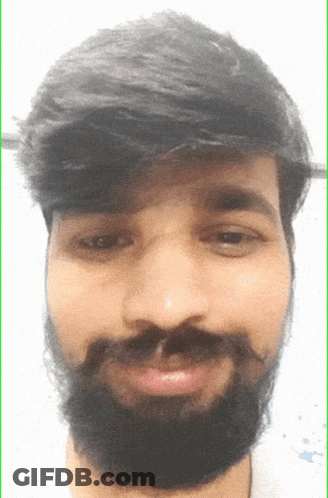 A Man With A Beard And Mustache Looks At The Camera GIF