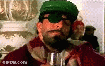 A Man With A Beard And Mustache Wearing A Green Hat And Sunglasses Is Holding A Glass Of Wine . GIF