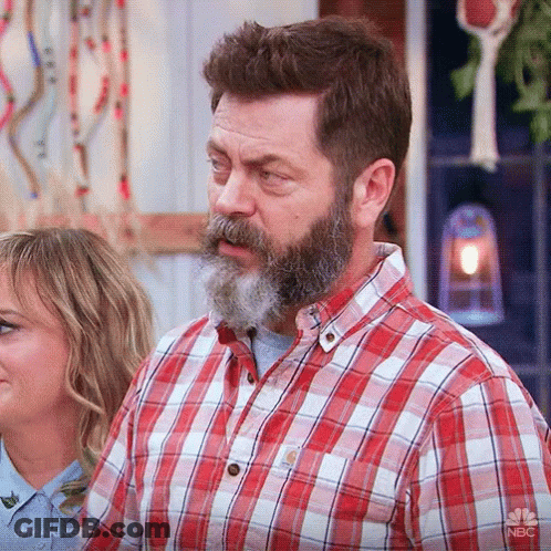 A Man With A Beard And Mustache Wearing A Plaid Shirt GIF