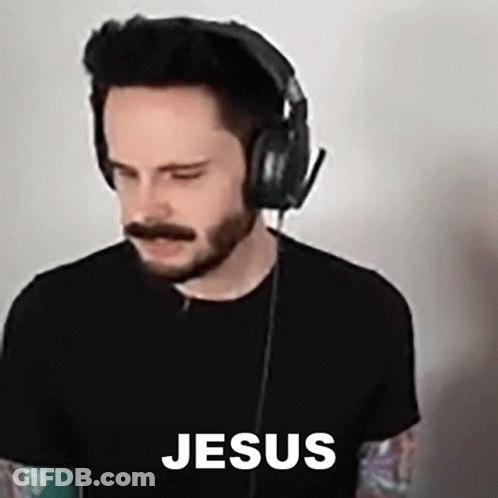 A Man With A Beard And Mustache Wearing Headphones And A Black Shirt With The Word Jesus On It . GIF