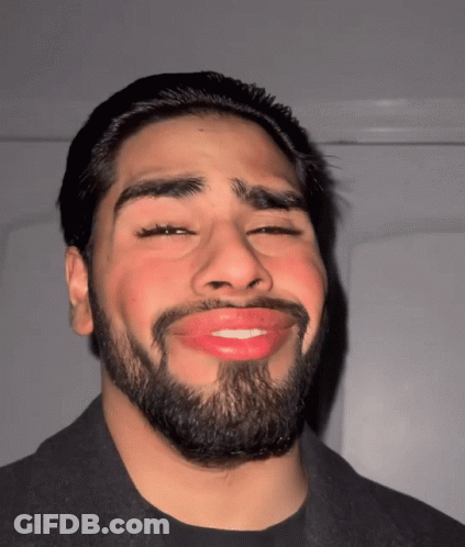 A Man With A Beard And Red Lips Is Smiling GIF