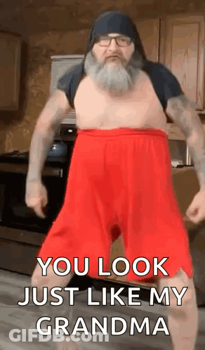 A Man With A Beard And Red Shorts Is Dancing In A Kitchen And Says `` You Look Just Like My Grandma '' . GIF