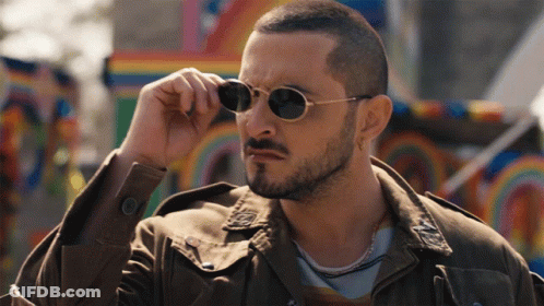 A Man With A Beard And Sunglasses Adjusts His Glasses GIF