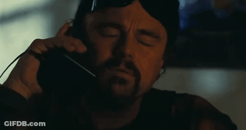 A Man With A Beard And Sunglasses Is Making A Funny Face With His Mouth Open . GIF