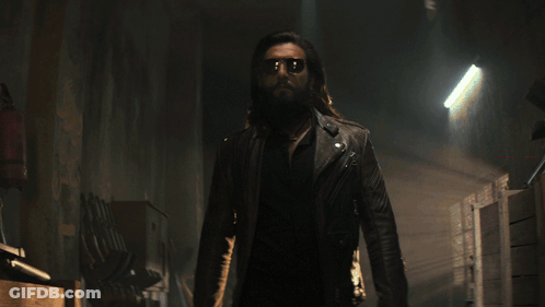 A Man With A Beard And Sunglasses Is Standing In A Hallway GIF