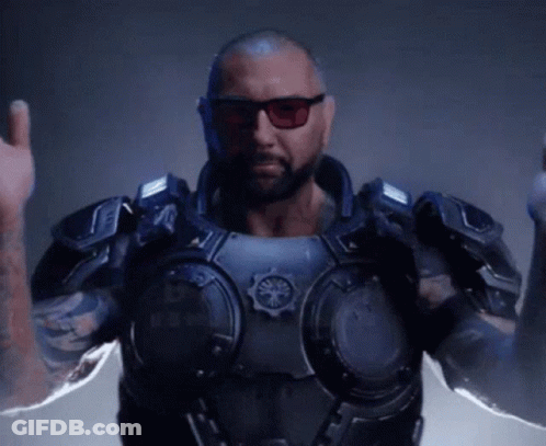 A Man With A Beard And Sunglasses Is Wearing A Futuristic Armored Suit . GIF