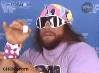 A Man With A Beard And Sunglasses Is Wearing A Purple Shirt And A Pink Hat . GIF