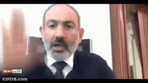 A Man With A Beard And Tie Is Talking On A Video Call With News Tv . GIF