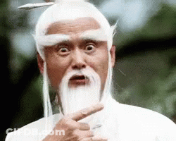 A Man With A Beard And White Hair Is Pointing At The Camera . GIF
