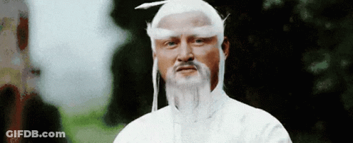 A Man With A Beard And White Hair Is Wearing A White Hat And A White Wig . GIF