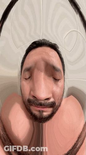 A Man With A Beard Has His Eyes Closed And Looks Like He Is Making A Funny Face GIF