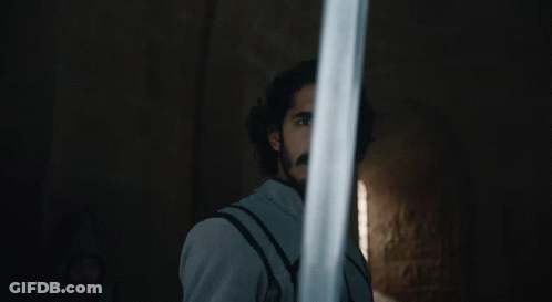 A Man With A Beard Holds A Sword In Front Of His Face GIF
