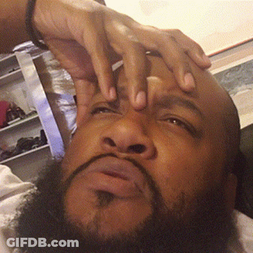 A Man With A Beard Holds His Hands To His Forehead GIF