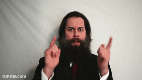 A Man With A Beard In A Suit And Tie Is Pointing Up GIF
