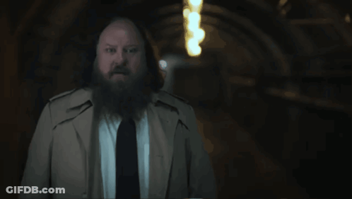 A Man With A Beard In A Trench Coat And Tie Says " That 'S What We Call A Mystery " GIF