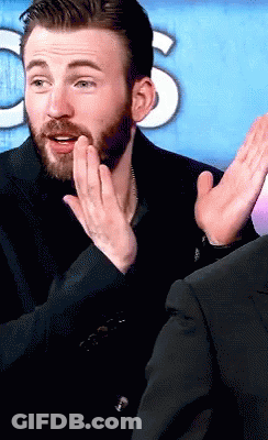 A Man With A Beard Is Applauding In Front Of A Sign That Says Cbs GIF
