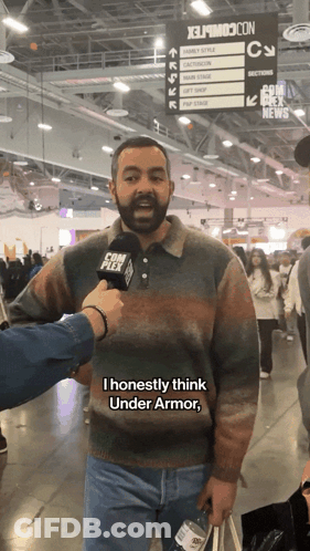 A Man With A Beard Is Being Interviewed At A Convention GIF