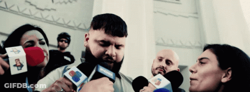 A Man With A Beard Is Being Interviewed By A Group Of People Holding Microphones That Say Cnn GIF