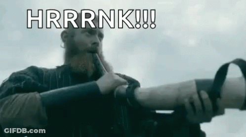 A Man With A Beard Is Blowing A Horn And Saying `` Hrrrnk '' . GIF