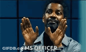 A Man With A Beard Is Clapping His Hands In A Room . GIF