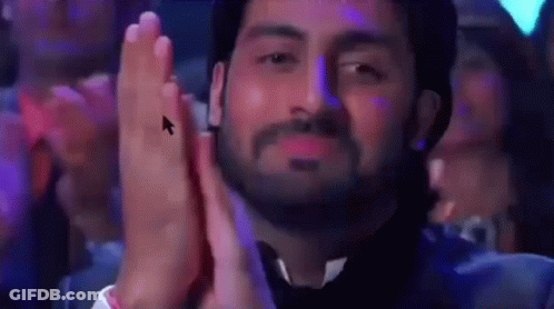 A Man With A Beard Is Clapping His Hands In Front Of A Computer Mouse . GIF