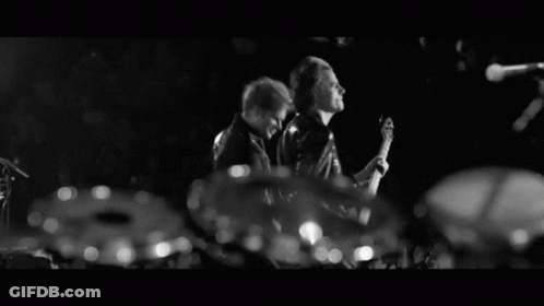 A Man With A Beard Is Clapping His Hands In The Dark GIF