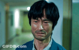 A Man With A Beard Is Crying In A Hallway With His Eyes Closed GIF