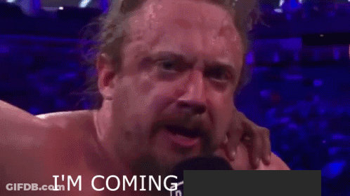 A Man With A Beard Is Crying In Front Of A Microphone With The Words I 'M Coming Written Below Him GIF