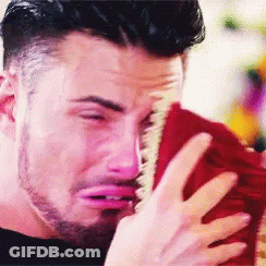 A Man With A Beard Is Crying While Holding A Red Towel GIF
