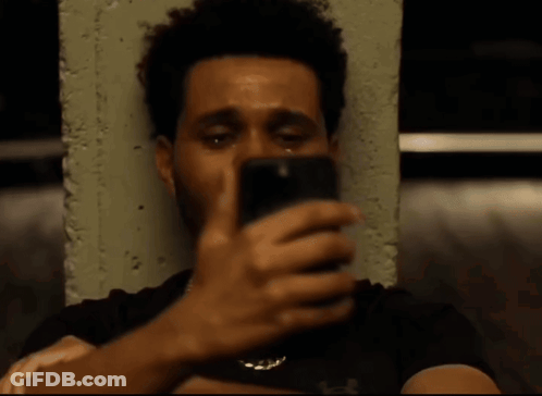 A Man With A Beard Is Crying While Sitting Next To A Concrete Wall . GIF