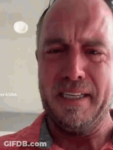 A Man With A Beard Is Crying While Wearing Sunglasses . GIF